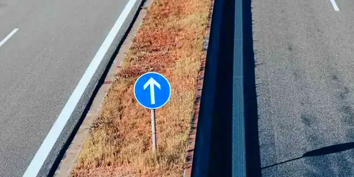 Rustige weg met blauw verkeersbord, het doel na een geslaagd theorie examen zonder faalangst